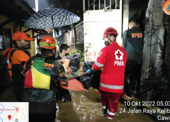 Petugas gabungan mengevakuasi warga yang terjebak banjir di Kelurahan Cawang, Jakarta Timur, Senin (10/10). Foto: BPBD DKI