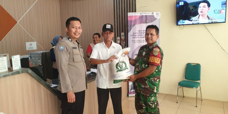 Bhabinkamtibmas Polsek Legok Monitoring Pembagian Beras di Desa Serdang Wetan